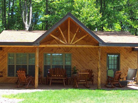 Covered porch with log posts and diagonal siding